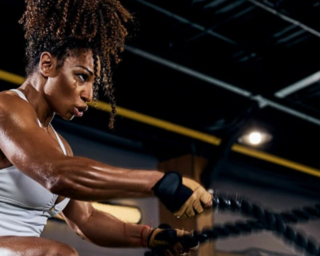 Woman training with battle ropes in a gym