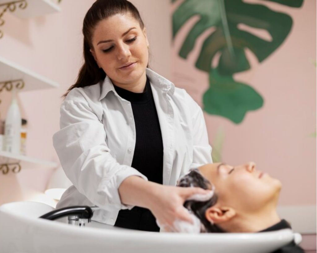 LaGrange Hair stylist rinsing and shampooing a client at a salon sink as part of daily towel and linen operations serviced by Southeastern Laundry