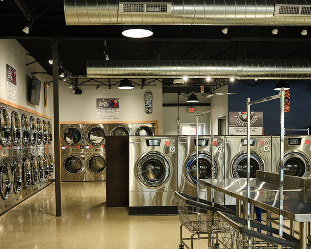 Modern Millbrook laundromat featuring rows of Speed Queen commercial washers and dryers.