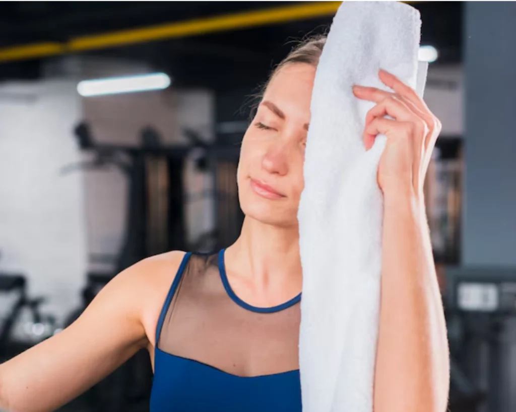 Gym member wiping sweat with a towel after a workout at a Greer, SC fitness facility.