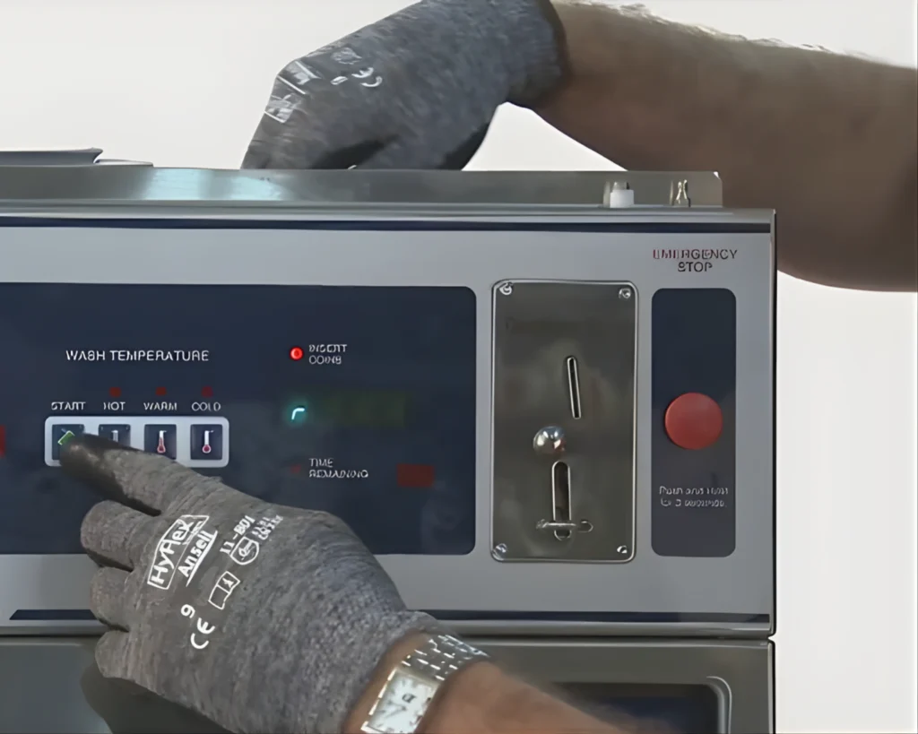 Technician adjusting commercial washer control panel for a Lexington laundry facility supported by SELaundry.