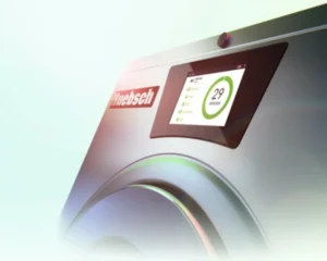 Close-up of Huebsch washer touchscreen displayed at a tampa laundromat equipment expo in a commercial setting.