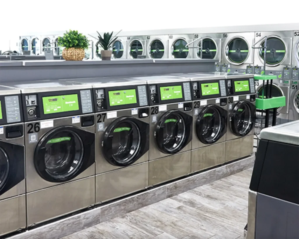 Modern laundromat layout with commercial washers, dryers, folding tables, and carts for Southeastern Laundry in Orlando.