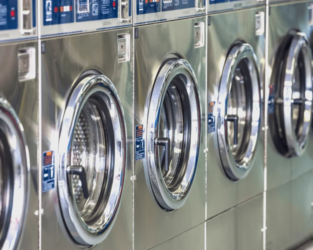 Apartment laundry room design with a visible row of front-loading washers for easier machine selection