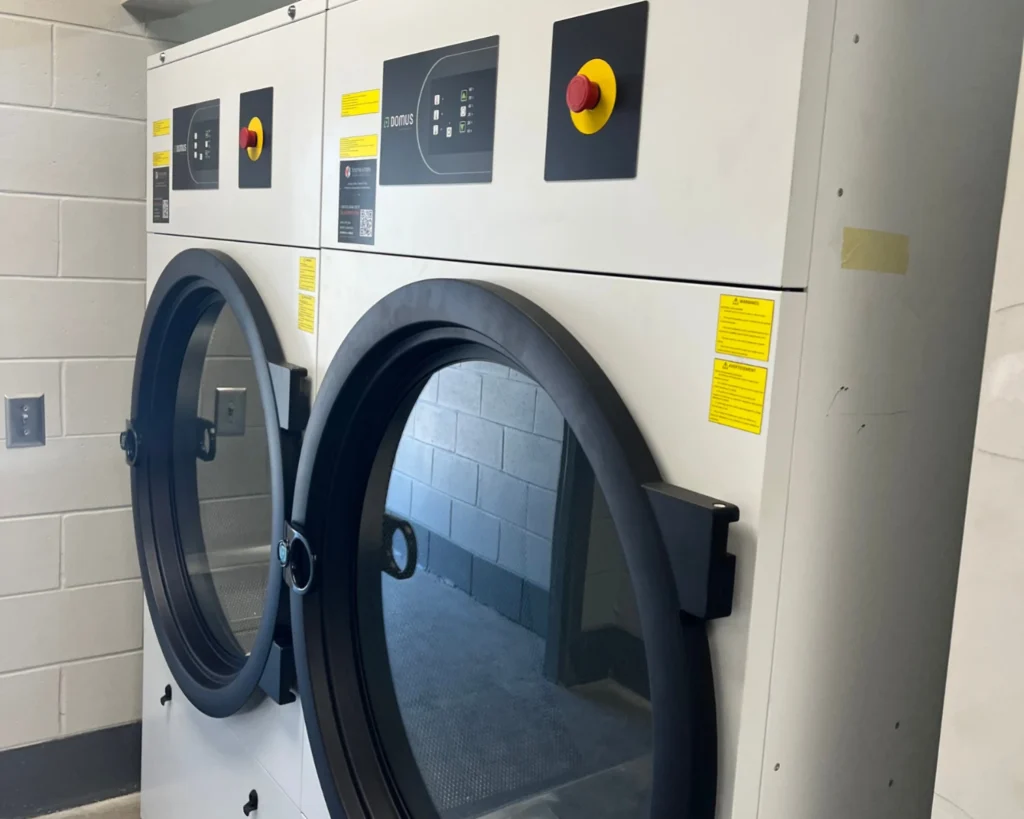 Commercial washer needs service when front-load laundry machines show odors, leaks, or slow drainage