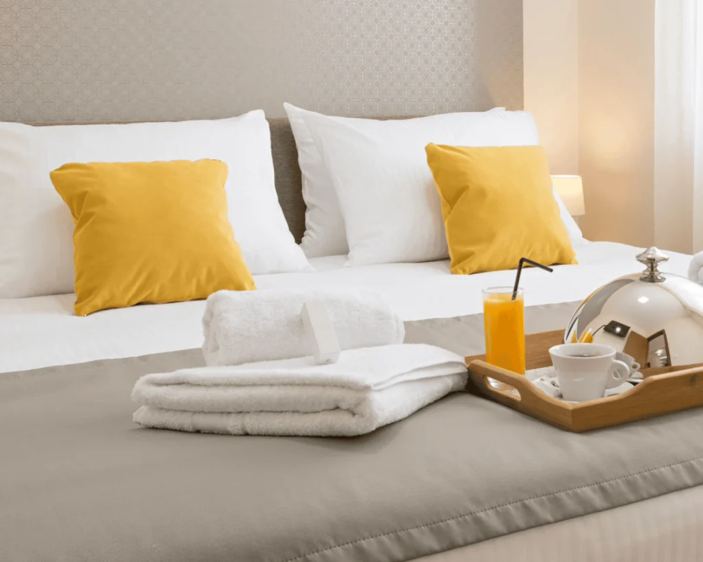 Fresh hotel bedding and folded towels maintained with hotel laundry best practices for clean, guest-ready linens.