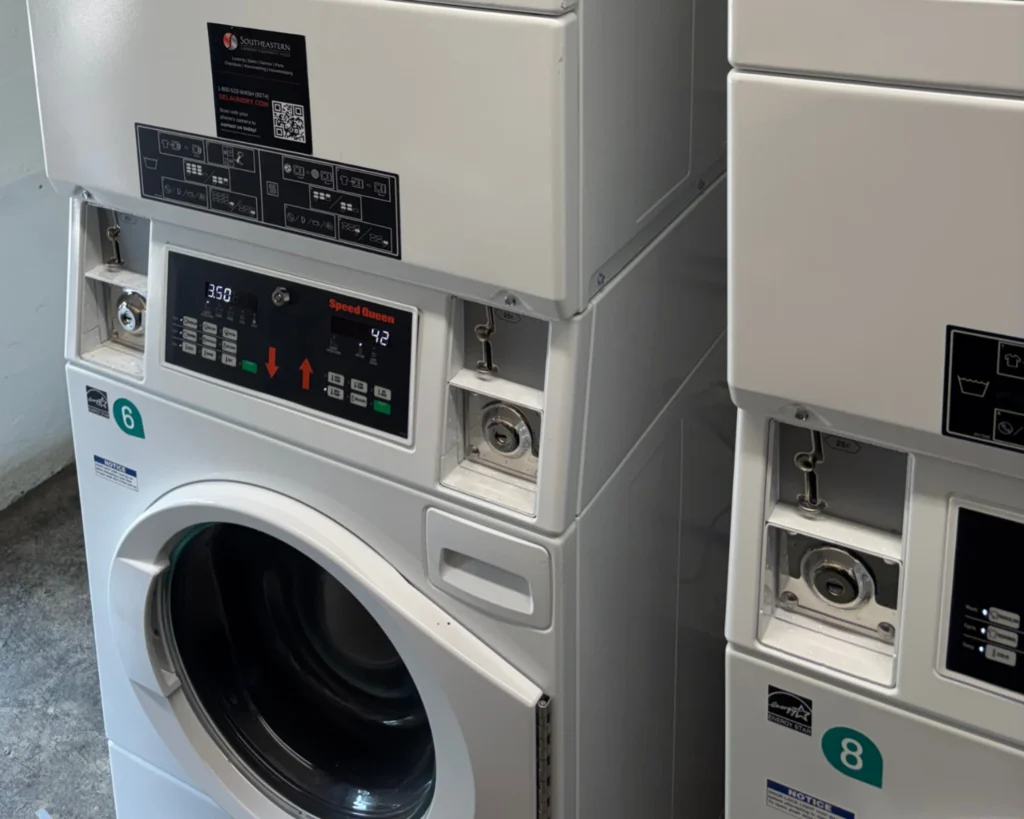 New laundromat owner evaluating stacked commercial washers for an efficient laundromat equipment layout.